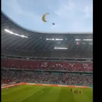 A Greenpeace activist lands at Allianz Arena with a parachute prior to the match between France and Germany in Munich