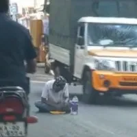 man eats tiffin on road