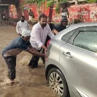 MLA Kotam Reddy helps to push vehicles stranded in rain water