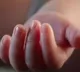 Mother dips babys fingers in hot oil  as it stops feeding