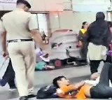 Police officer wakes up passengers sleeping on platform by spraying water on their faces