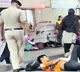 Police officer wakes up passengers sleeping on platform by spraying water on their faces