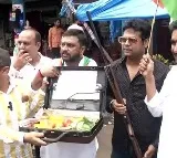 Cong workers buy tomatoes carrying briefcase and gun to protest against price rise