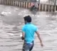 People wade in knee deep water for floating milk packets in Machilipatnam