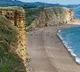 Tourists Narrowly Escape As Crumbling Cliff Smashes Into UK Beach