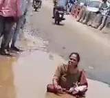 Woman sits in pothole to flag poor condition of roads in Hyderabad