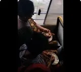Women peels garlic while free traveling in TSRTC bus
