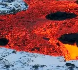 fire vs ice lava oozing over snow in Iceland