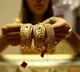 Gold edges lower on stronger dollar, Fed minutes weigh on rate-cut hopes