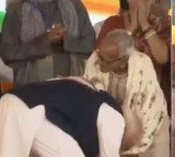 PM touches feet hugs BJPs oldest Bengal worker at Suvendu Adhikaris oath event