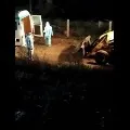 Corona victims dead bodies dumped into grave with an earth mover
