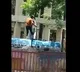 Water Tanker driver cleans his legs while standing upon the tanker